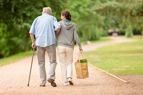 A woman helping senior man with shopping.