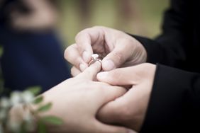 Wedding ceremony moment when the bride just placed the wedding ring on the groom's finger.