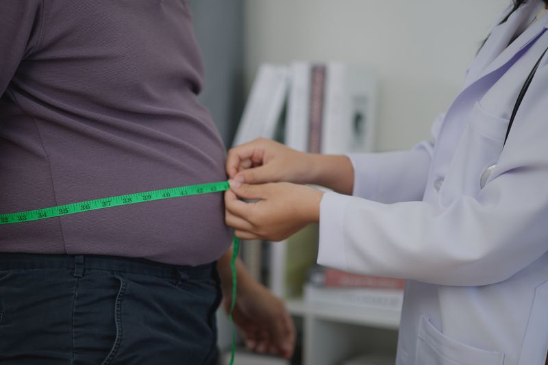 Doctor measuring a patient's waist size
