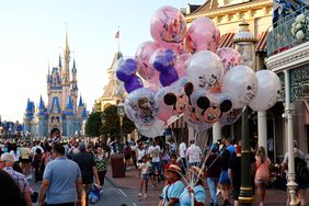 A vendor sells balloons along Main Street in front of Cinderella's Castle as the sun sets at the Magic Kingdom Park at Walt Disney World.