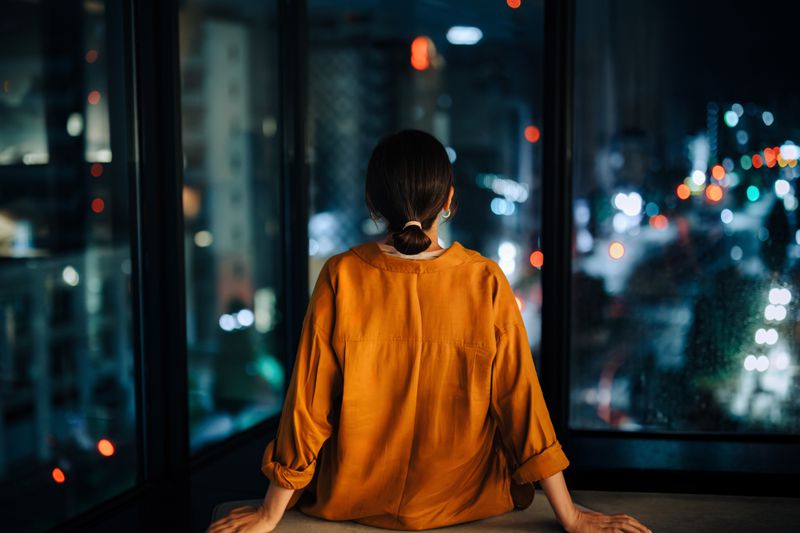 Woman staring out her window.