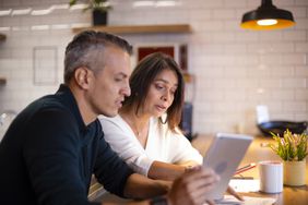Couple in their 40s or 50s looking with concern at online mortgage rates