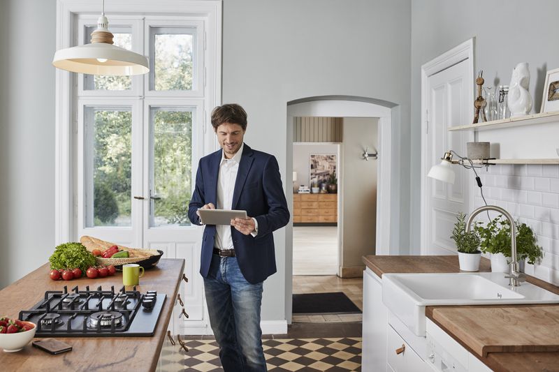 Insurance inspector walking through home with tablet doing insurance inspection