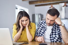 Couple sitting at a desk with a laptop and a calculator