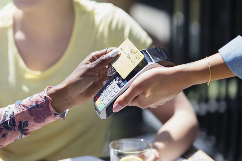 Woman Paying Waitress With Smart Card
