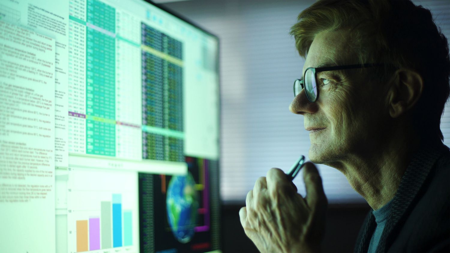 An investor studies economic charts on a computer screen.