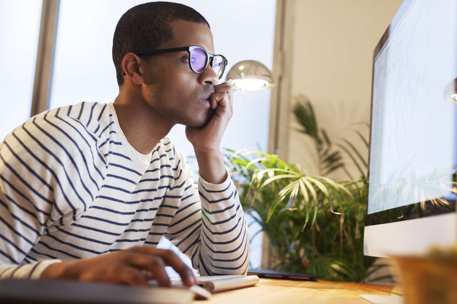 Man reading on his computer about the right time to buy a house