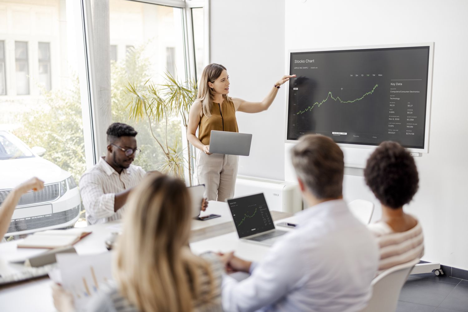Business meeting with a presenter showing financial data