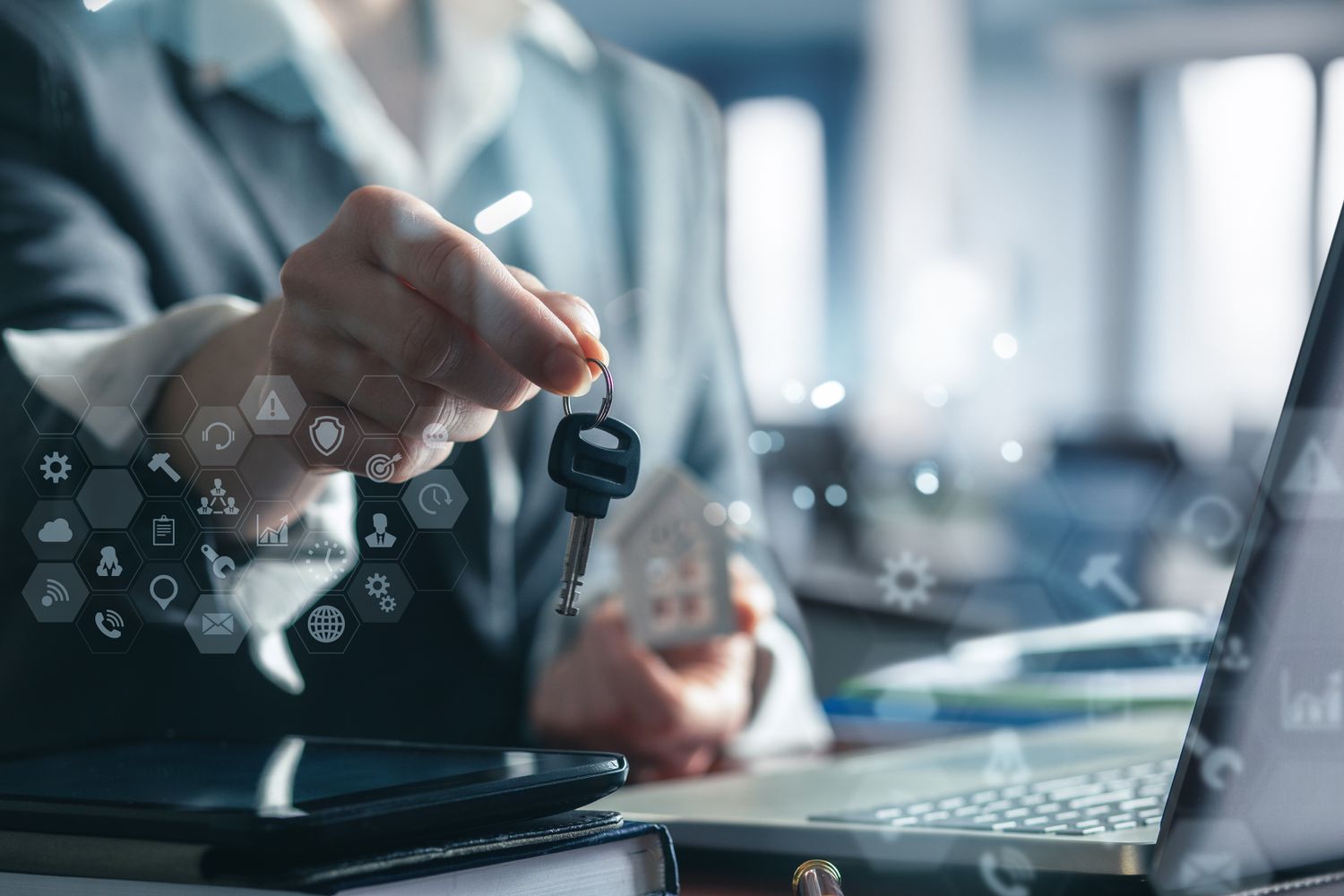 A person sitting at a computer and holding a key