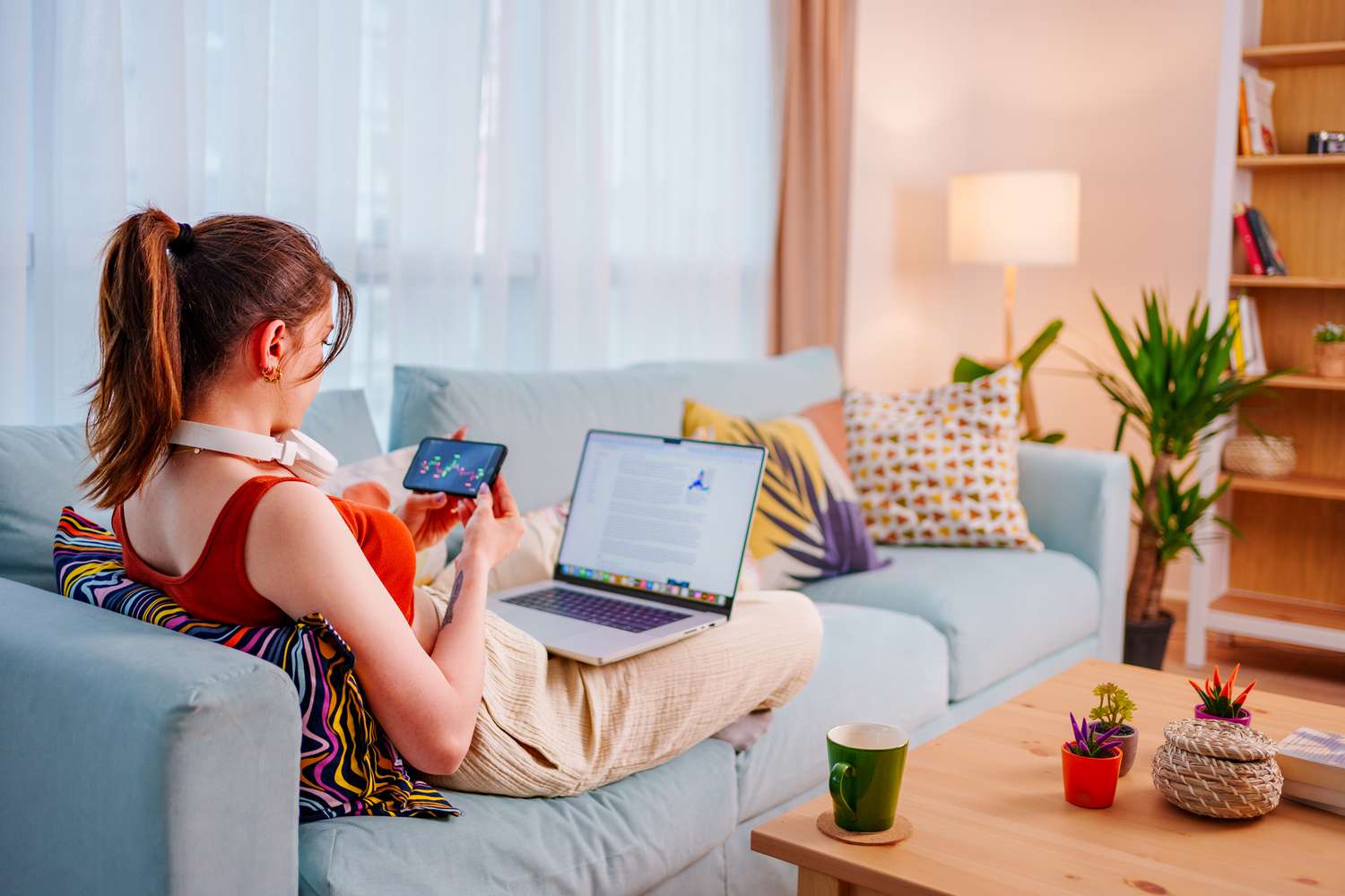 Trader watching cryptocurrency prices on couch