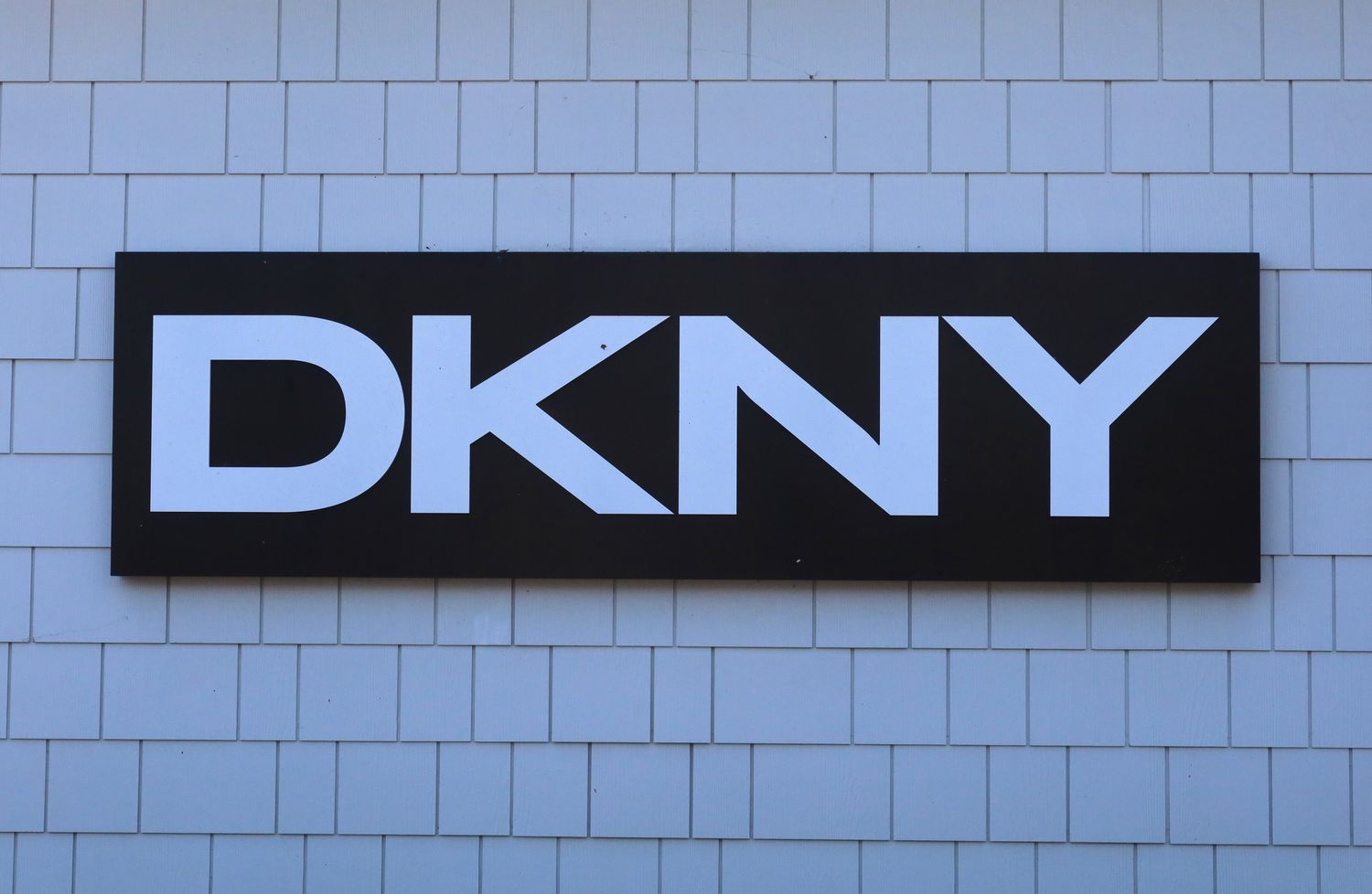 A DKNY sign hangs in front of their store at the Woodbury Common Premium Outlets shopping mall in Central Valley, New York