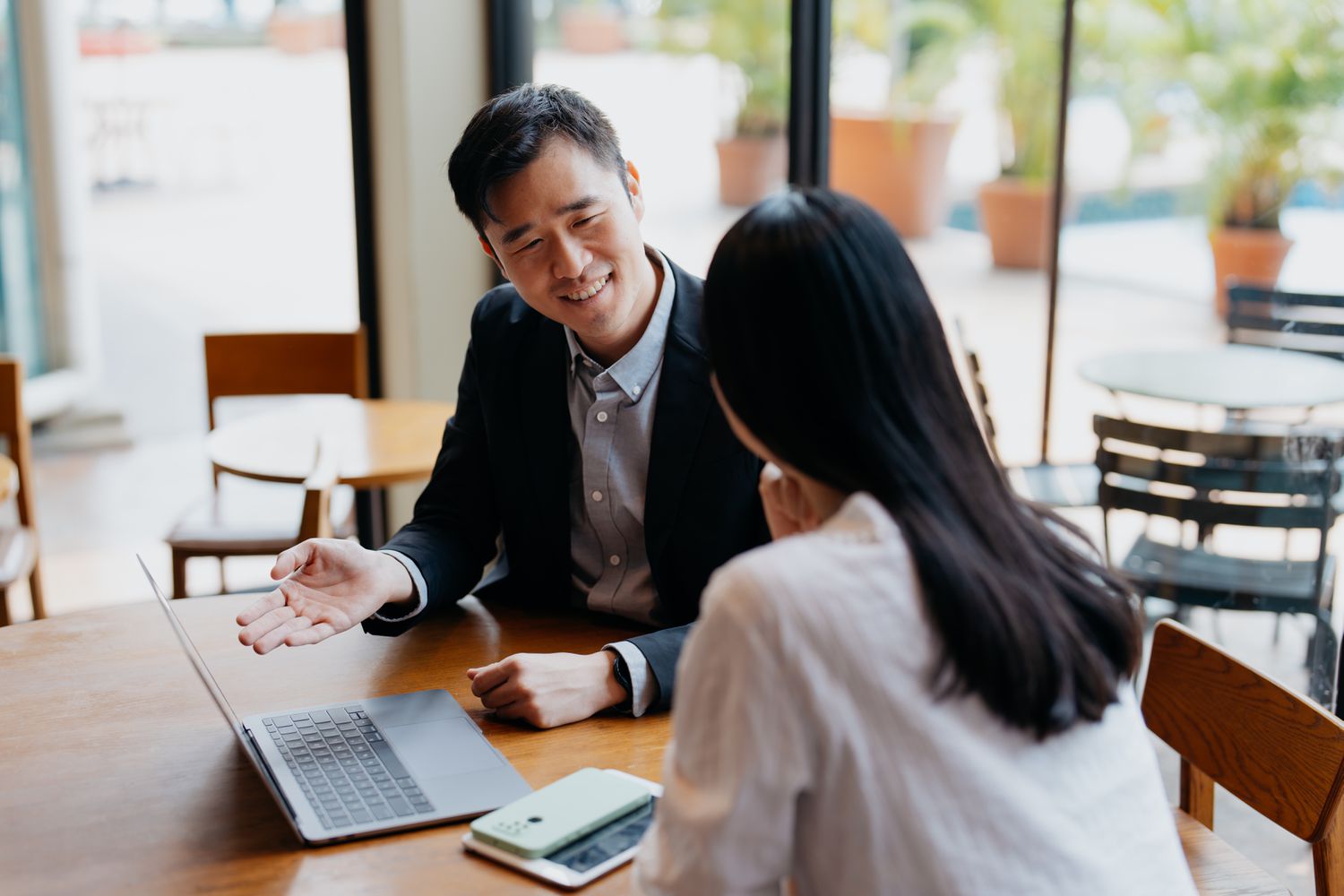 insurance agent has discussion with client in cafe