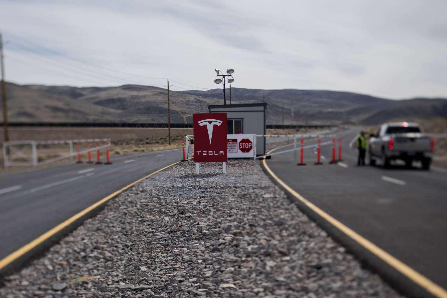 A Tesla sign sits outside of a Nevada battery factory site.