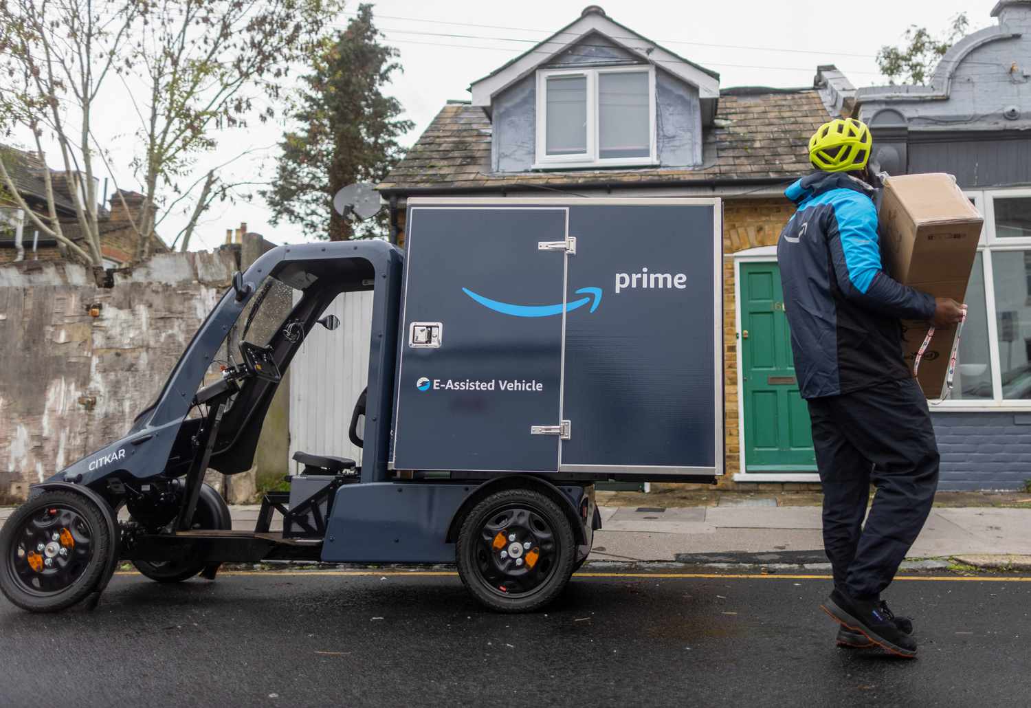 An employee delivers a parcel from an Amazon.com Inc. electric cargo delivery bike in Croydon, UK, 