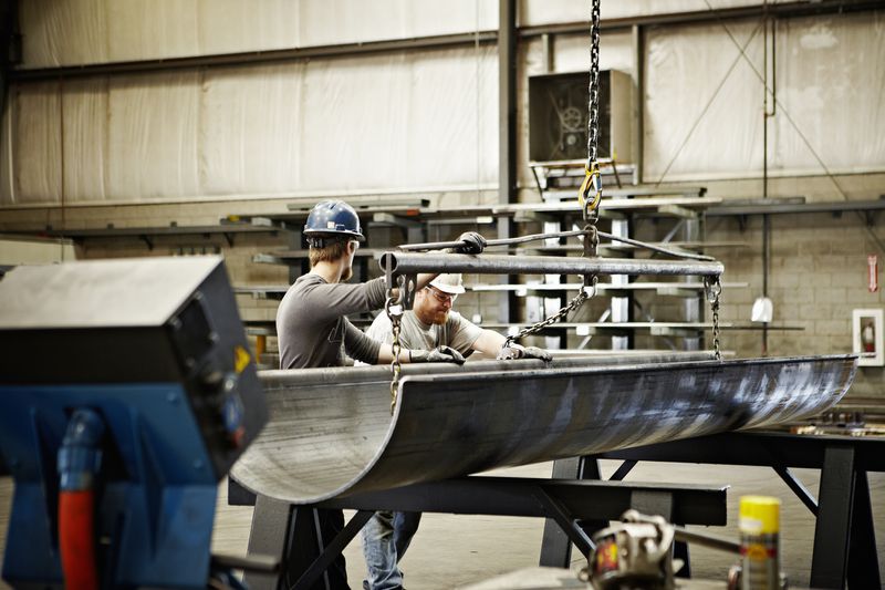 Steel workers adjusting position of formed steel