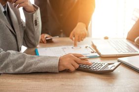 Two Business People Calculate Their Business in the Office