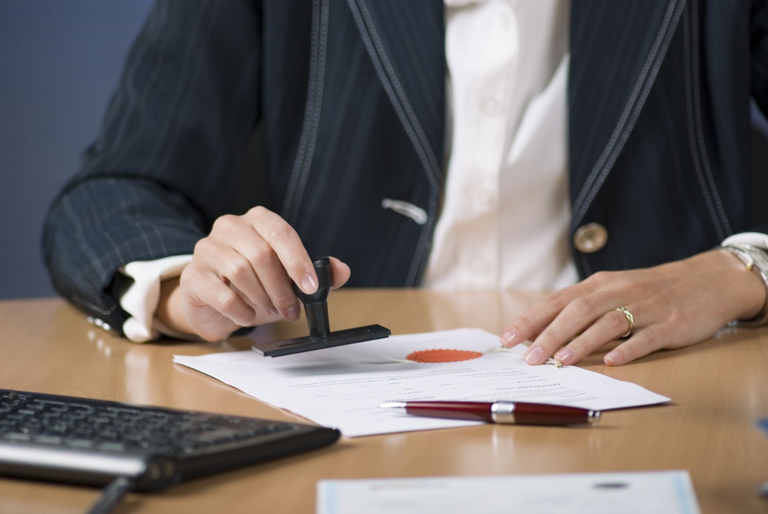 person stamping documents on desk