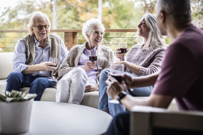 Elderly couples enjoying wine outside in the backyard of vacation home.