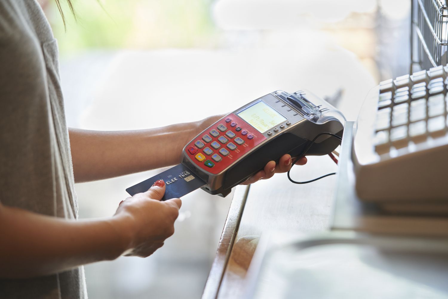 Woman paying with credit card terminal