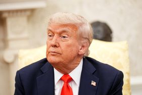 Donald Trump seated, in a formal setting