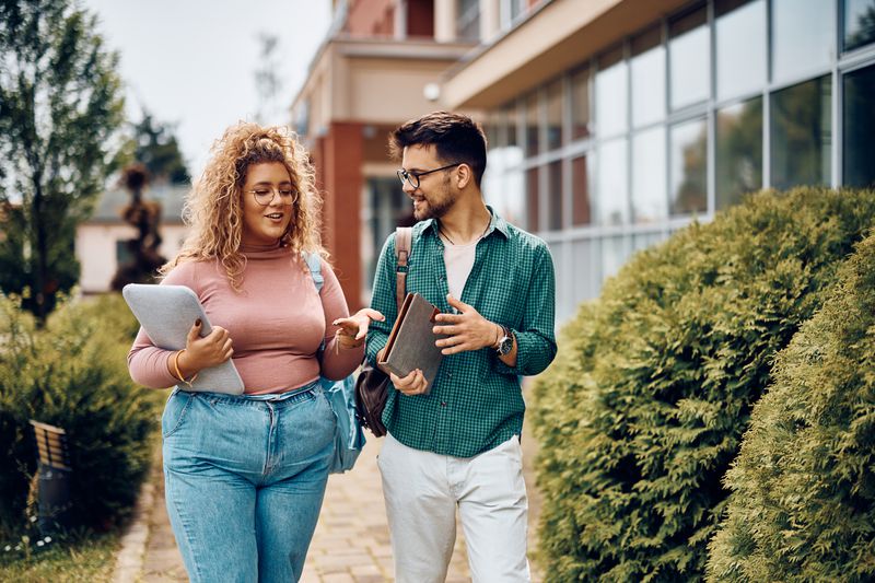 Friends walk through the campus of one of the universities with the largest endowments