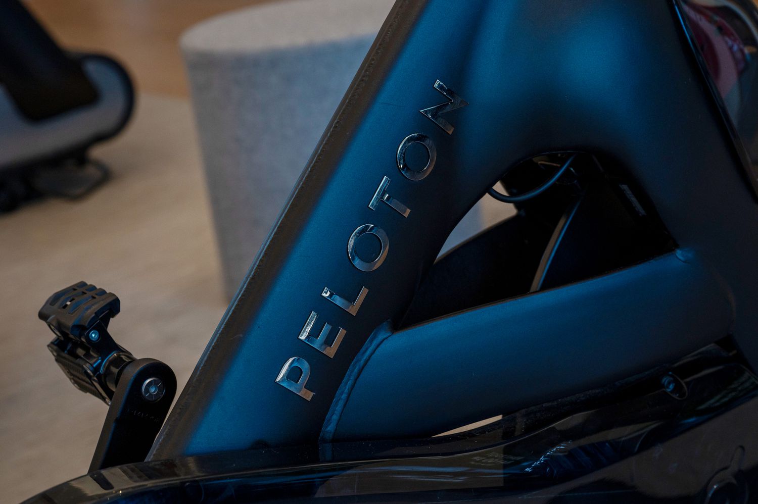 The Peoloton logo is seen on the side of a stationary bike.
