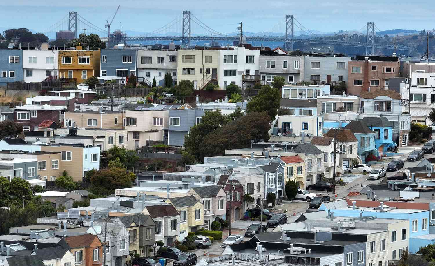 In an aerial view, homes stand in front of the Oakland-San Francisco Bay Bridge on June 09, 2023 in San Francisco, California.
