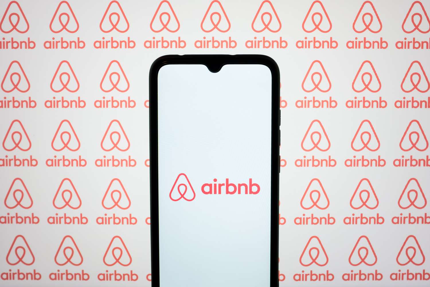 The Airbnb logos are being displayed on a smartphone screen and on a computer screen in Athens, Greece, on May 10, 2024