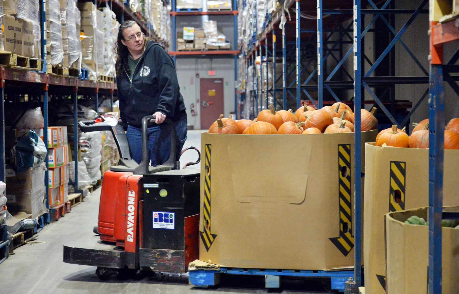 Food bank warehouse worker Tammie Racine stocks fresh farm produce collected through the "Harvest for All" donation program.