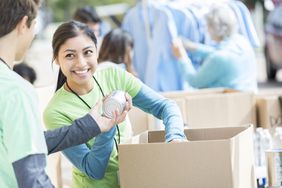 A woman passing out canned goods