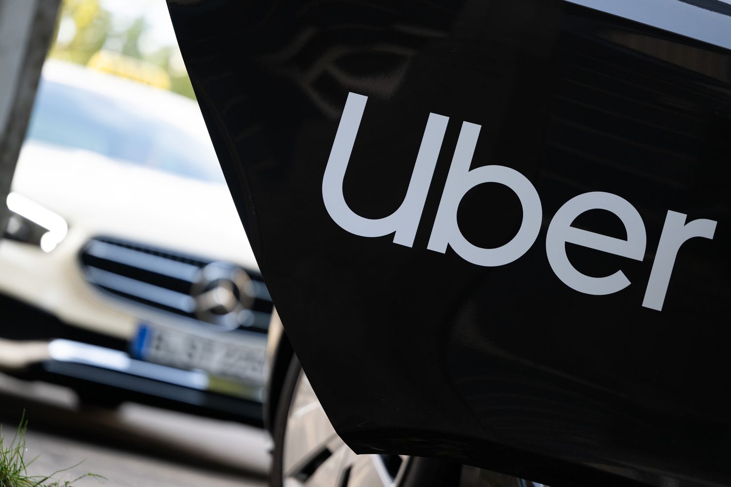 A rental car with a sign from the mobility service provider and ride broker Uber.