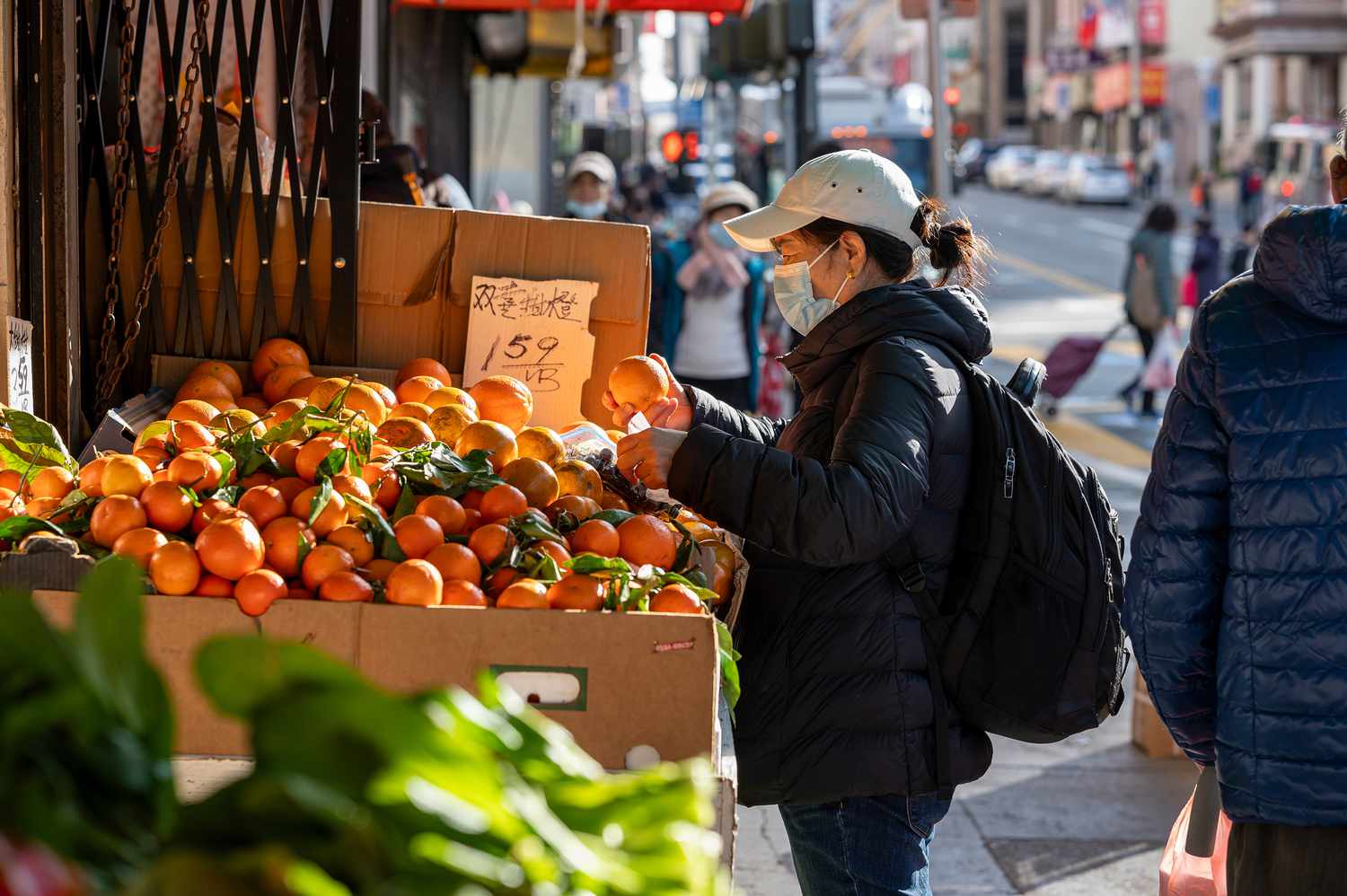 A shopper selects oranges in the Chinatown district of San Francisco, California, US, on Monday, Jan. 6, 2025. 