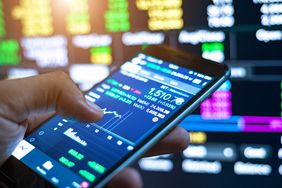 Cropped Image Of Man Checking Stock Market On Mobile Phone