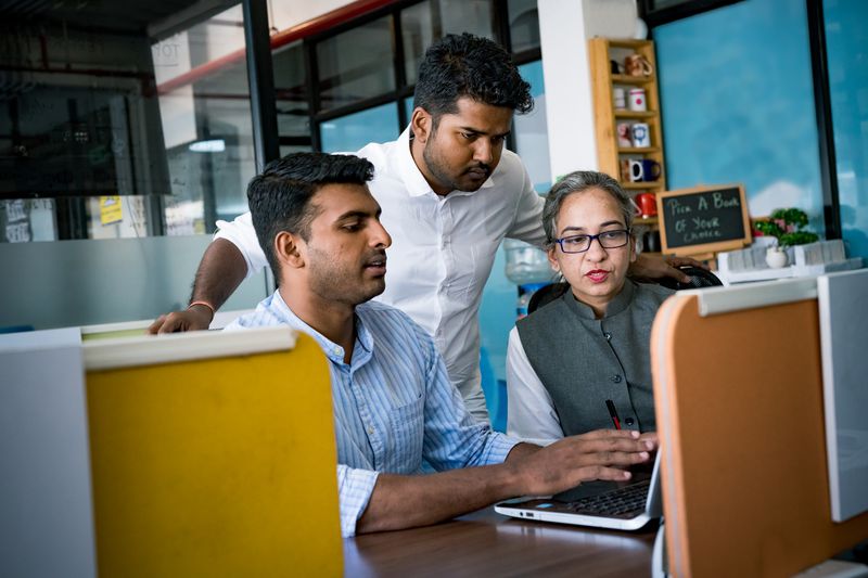 Indian professionals working at a desk at a corporate office