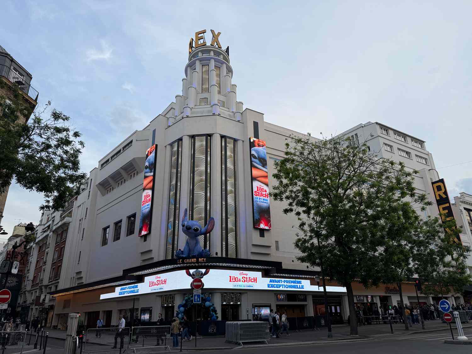 An imitation of Stitch from 'Lilo & Stitch' sits atop a theater awning in Paris. 