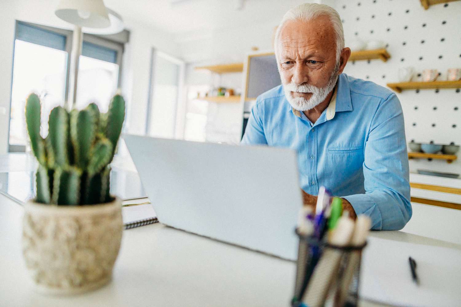Older man reading about whether a biweekly mortgage payment is a good idea on his computer