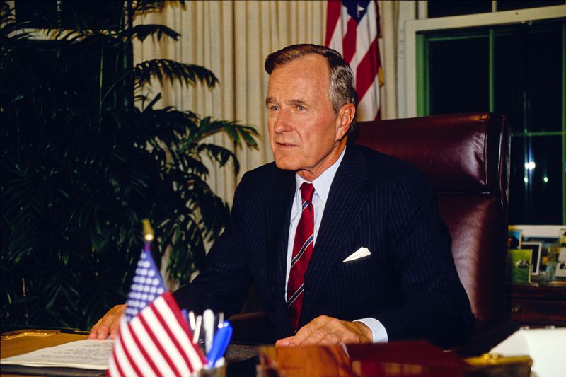 US President George HW Bush sits behind his desk in the White House's Oval Office