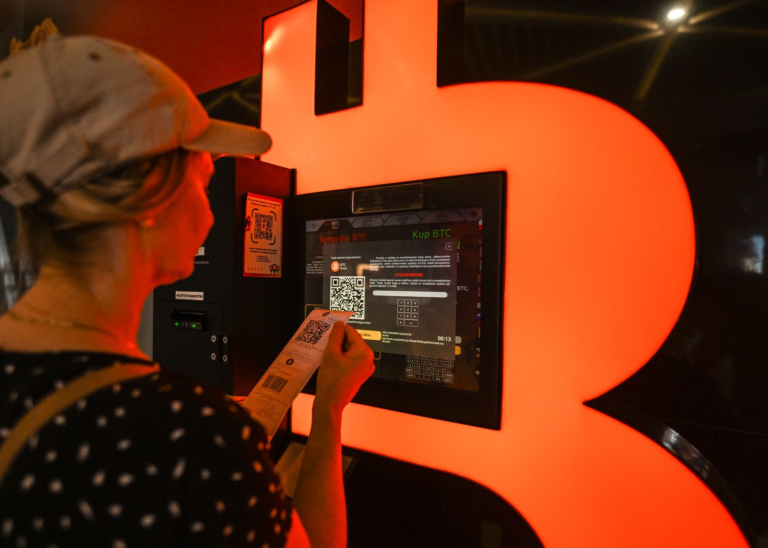 A woman reviewing the latest Bitcoin prices outside a Bitcoin ATM, on August 4, 2024, in Rzeszow, Subcarpathian Voivodeship, Poland. 