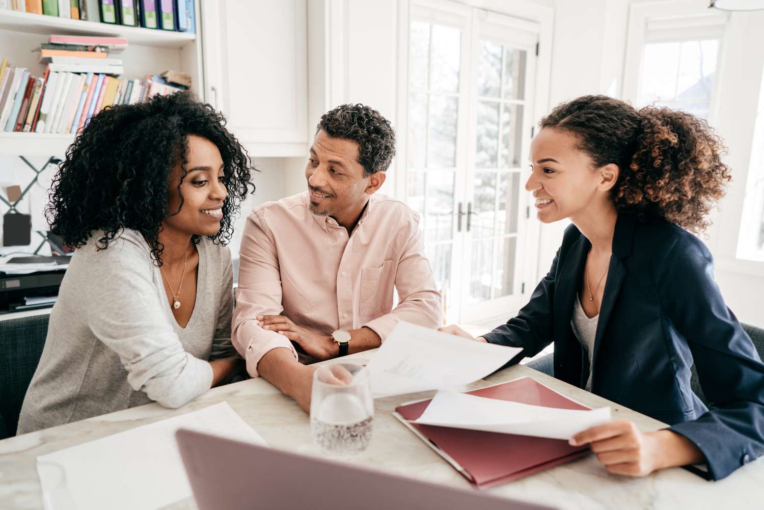 Real estate agent explaining to a couple about the tax service fee that included in property's closing cost.