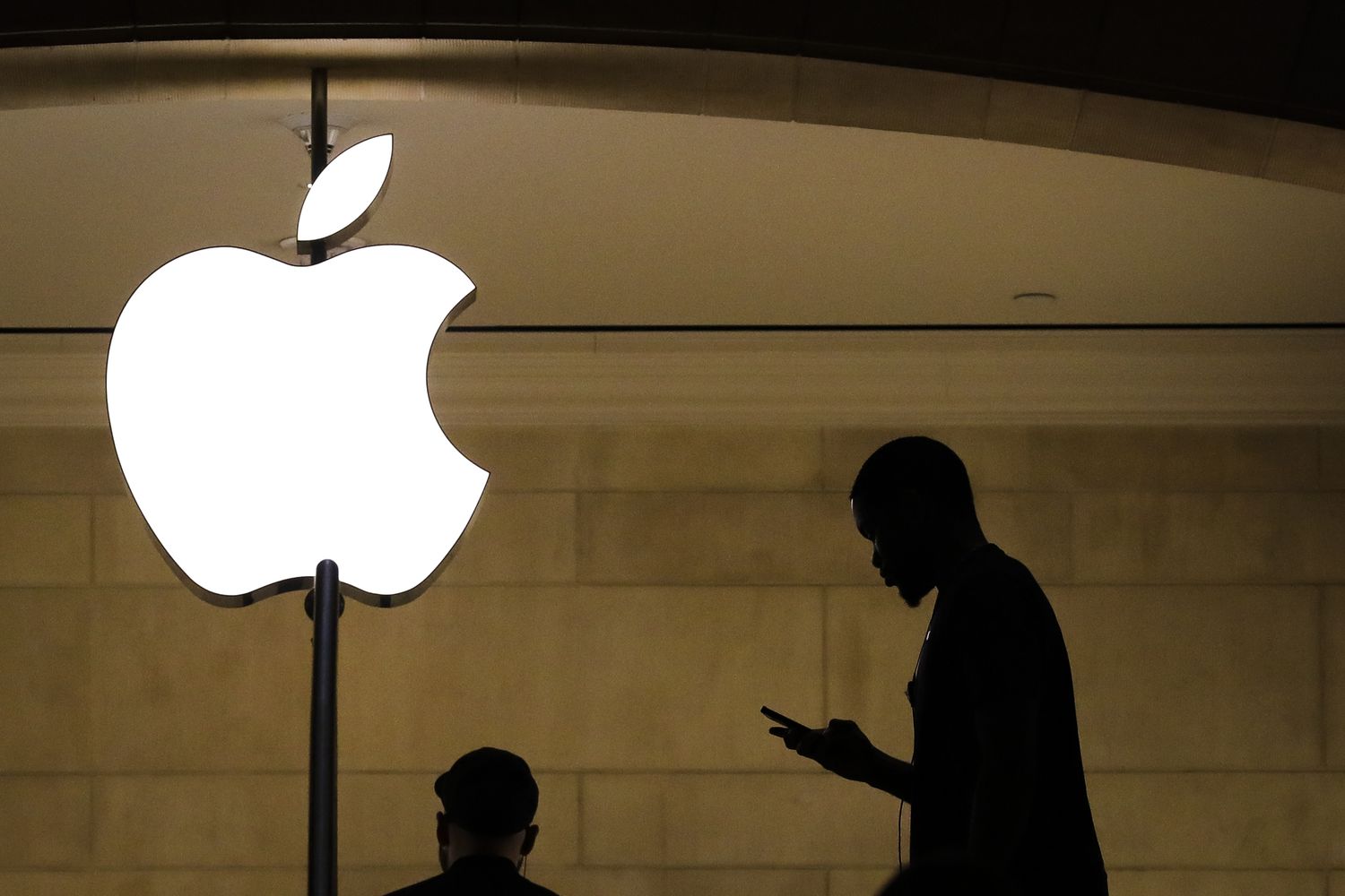 A man checks his phone in an Apple retail store.