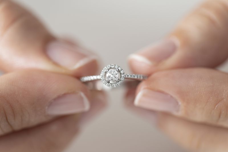 a woman's hands holding a diamond ring