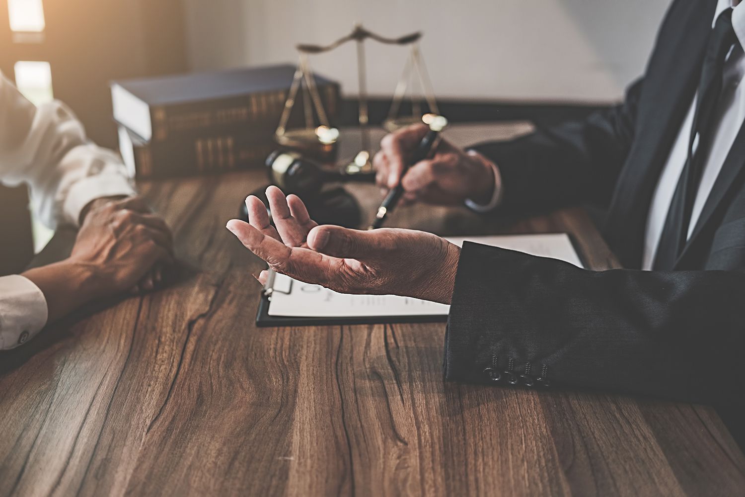 Midsection of Judge and Client Sitting at Table in Office