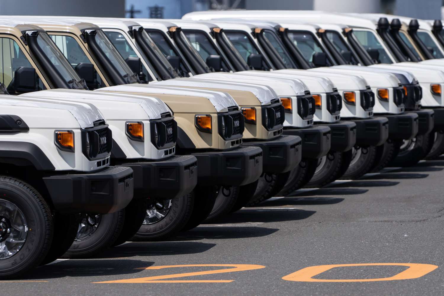 Toyota trucks awaiting shipment are parked at a port on March 27, 2025 in Yokohama, Japan