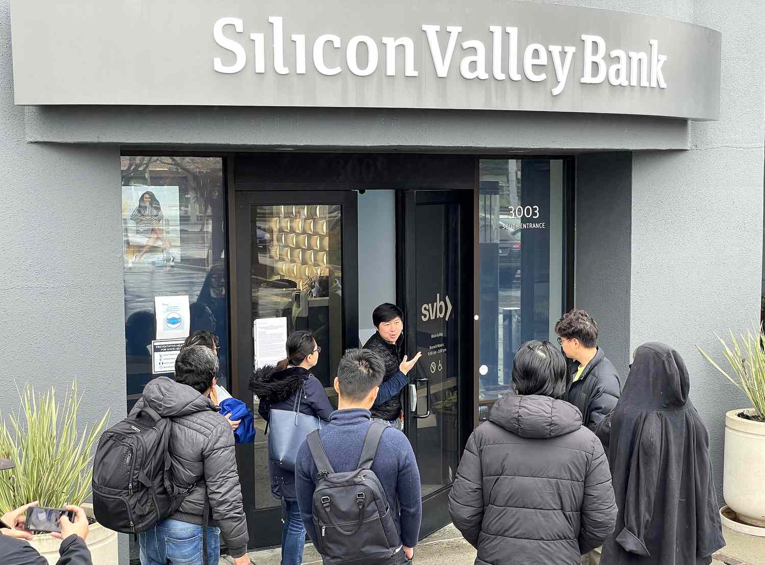 A worker (C) tells people that the Silicon Valley Bank (SVB) headquarters is closed on March 10, 2023 in Santa Clara, California.