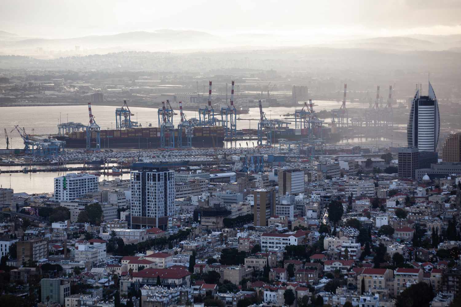Cargo ships are seen at Israel's Haifa commercial shipping port in the Mediterranean Sea on December 13, 2023. In solidarity with Palestinians in Gaza, Yemen's Houthis are warning that they will target cargo vessels sailing through the Red Sea if they are heading for Israeli ports, regardless of their nationality. 