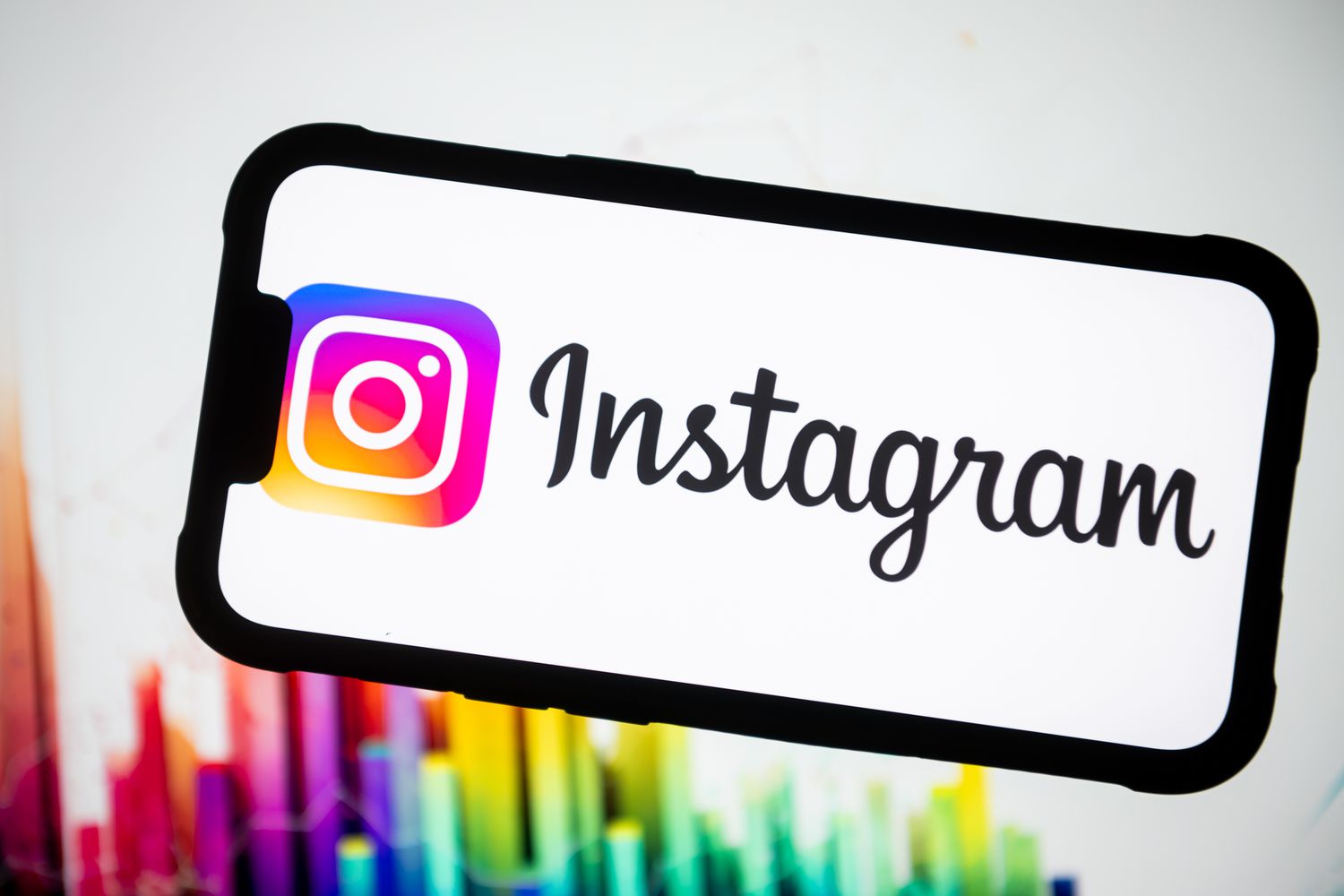 Instagram logo is displayed on a smartphone