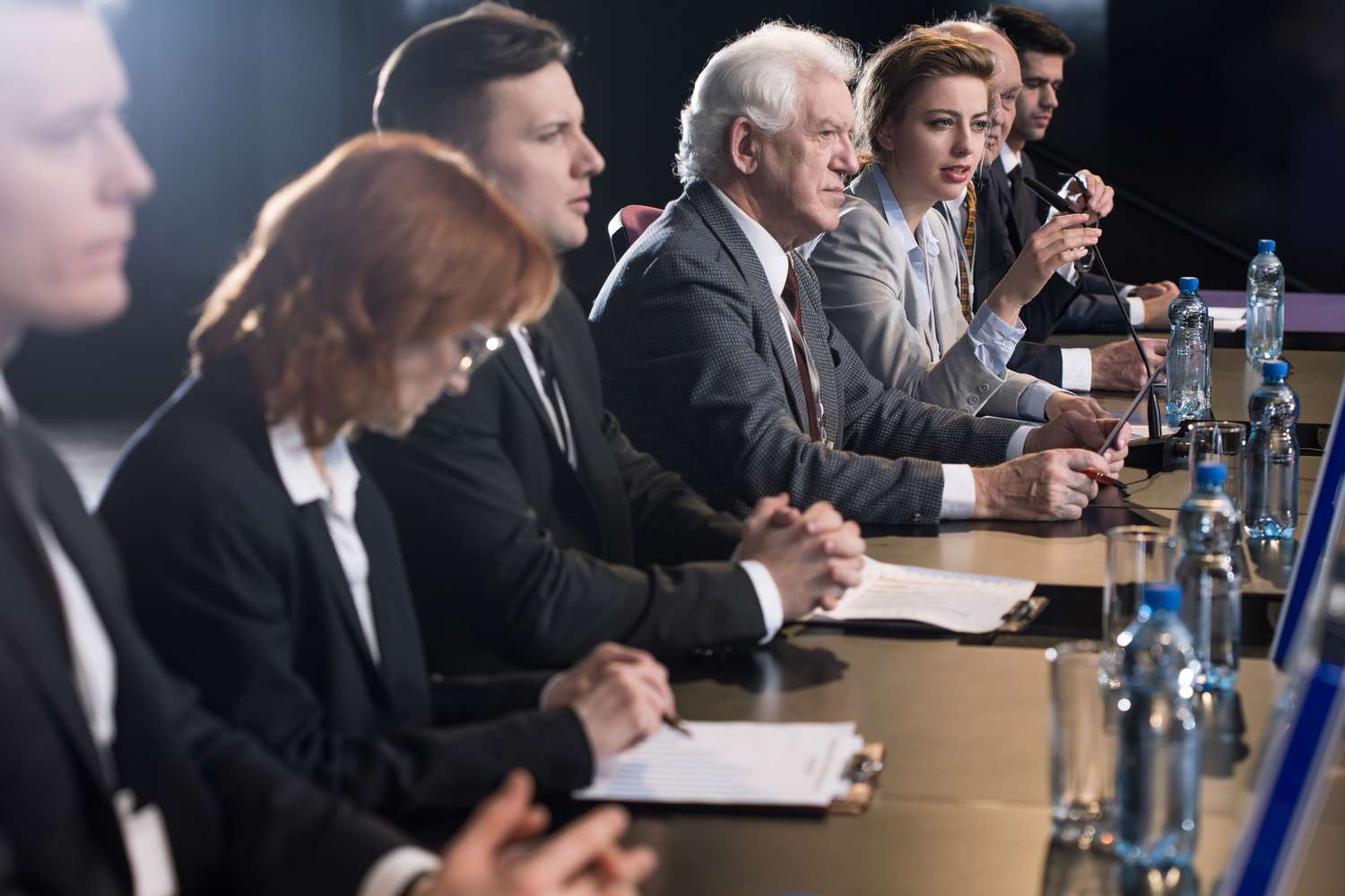 Government officials in a press conference explaining policies to manage country's debt.