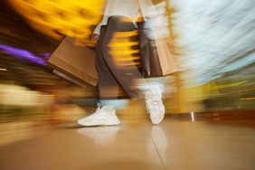 A blurred image of a shopper carrying bags. 