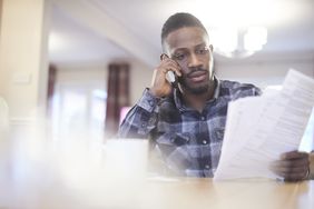 A young man reviews a car insurance policy over the phone.