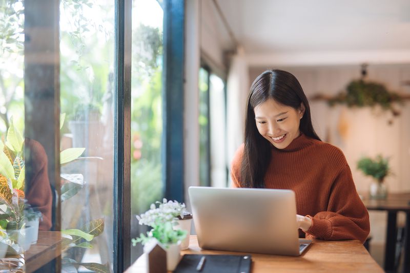 Woman Working at a Coffee Shop With a Laptop